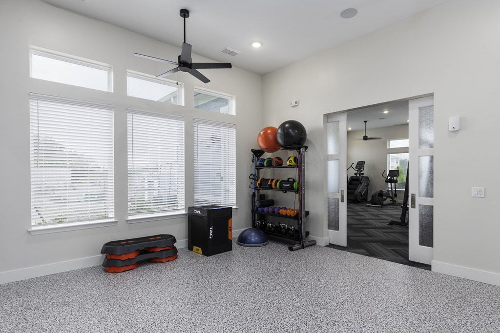 a living room with a large window and a ceiling fan