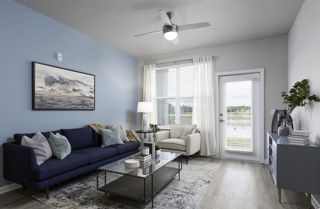 an open living room with a blue couch and a coffee table
