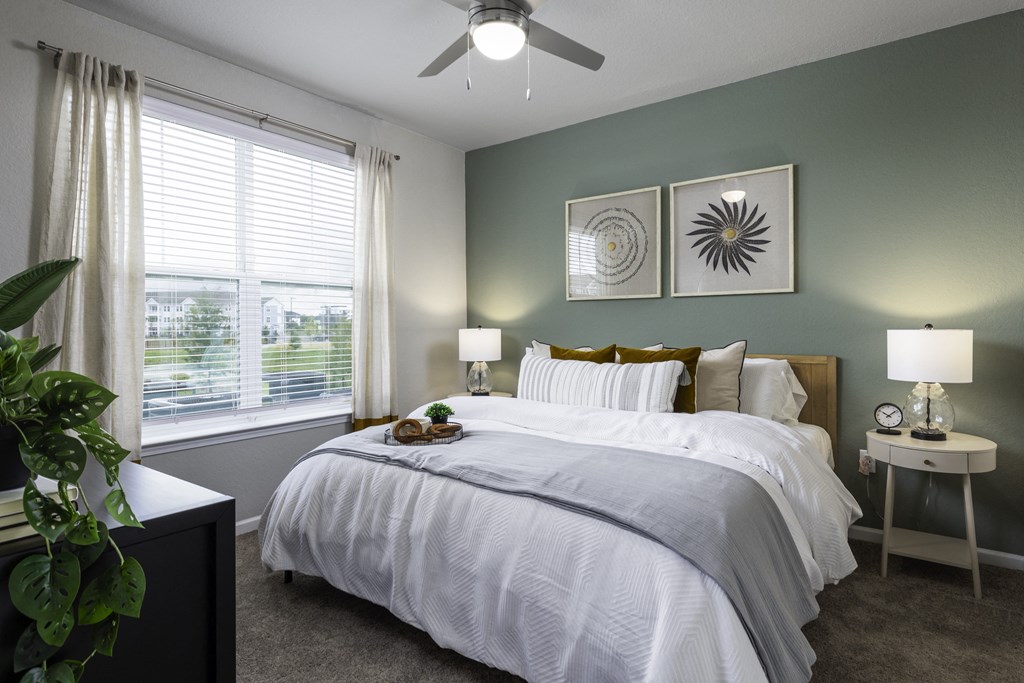 a bedroom with a large bed and a ceiling fan