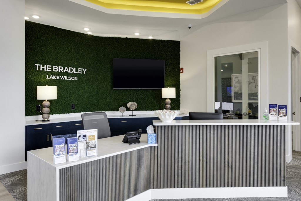 the law firm reception desk with green turf wall behind it