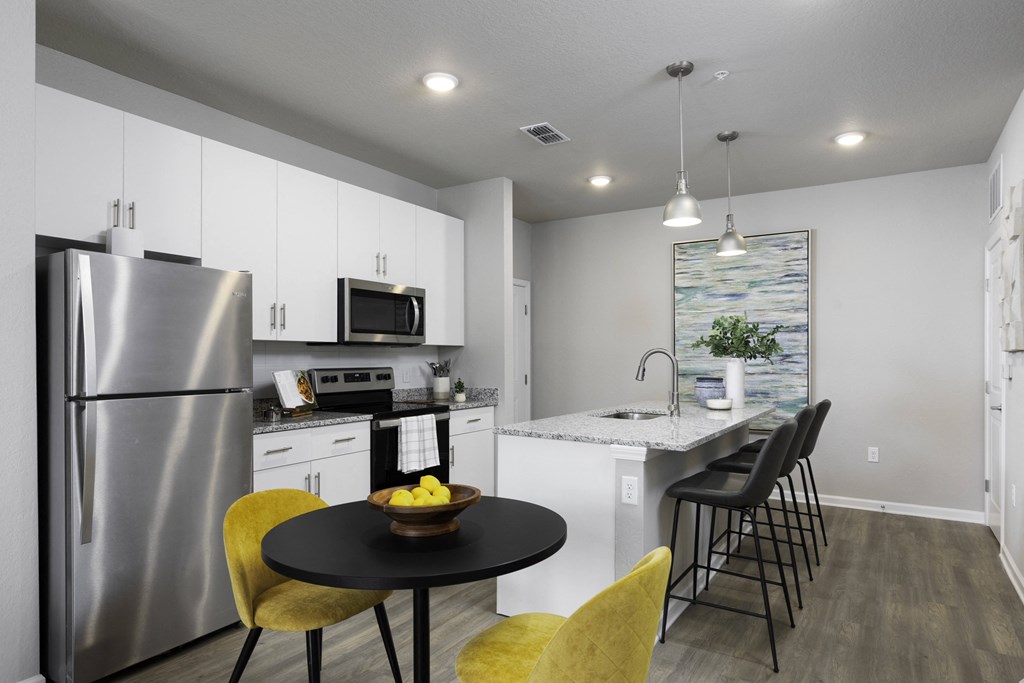 a kitchen with stainless steel appliances and a table with chairs