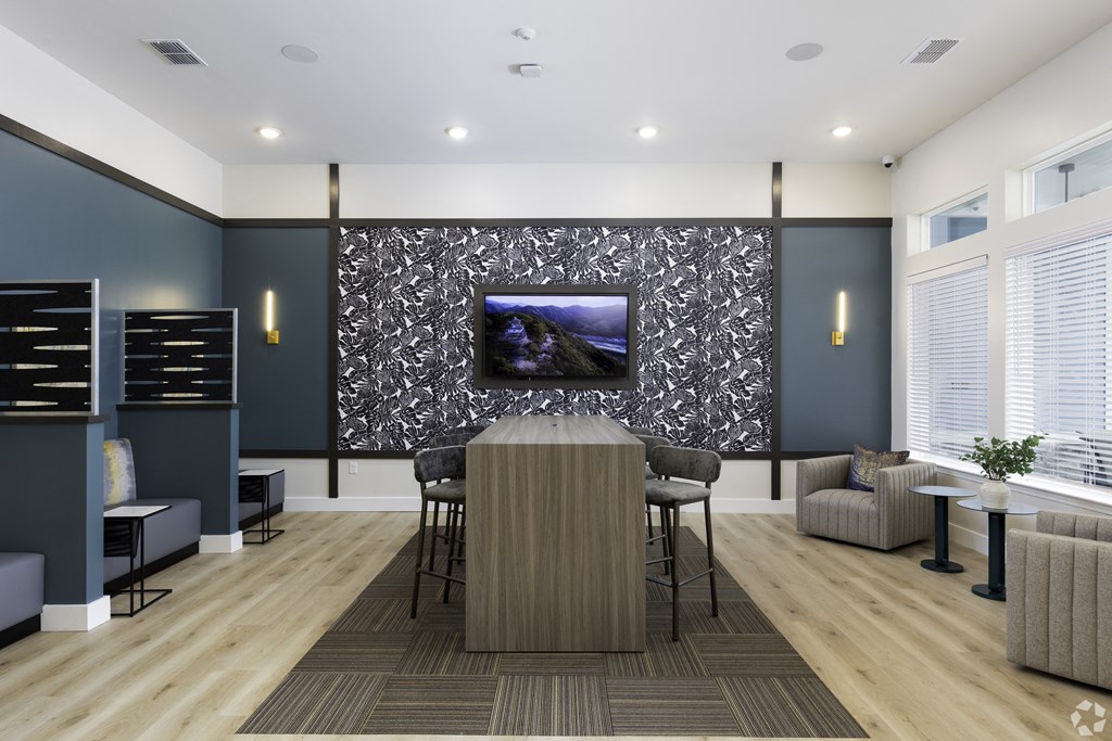 a conference room with a table and chairs and a tv on the wall