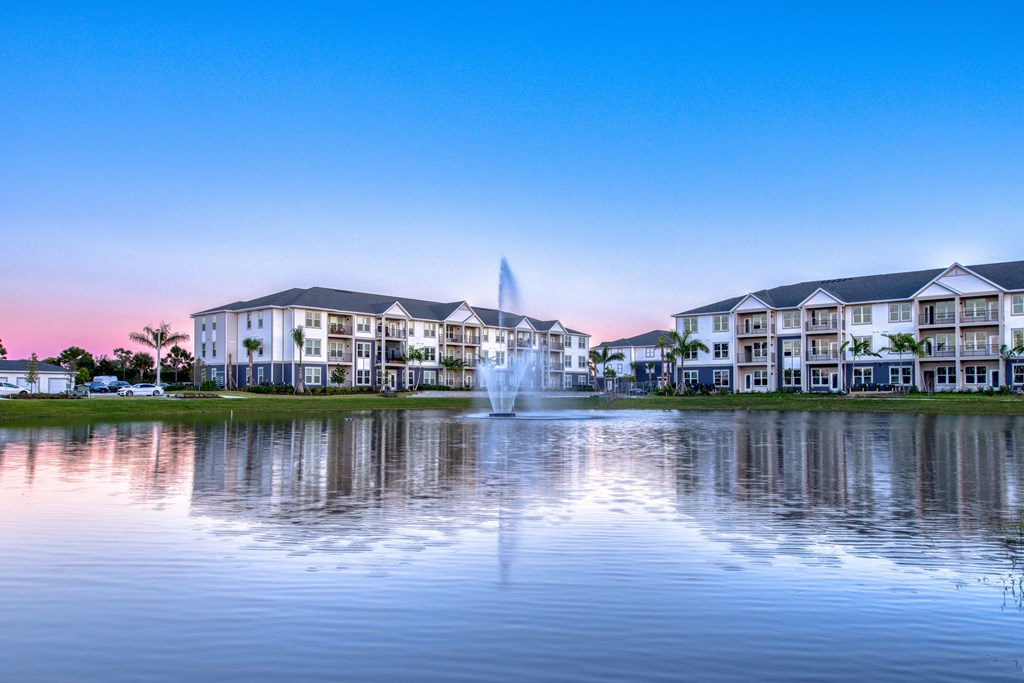 a fountain in the water in front of a building
