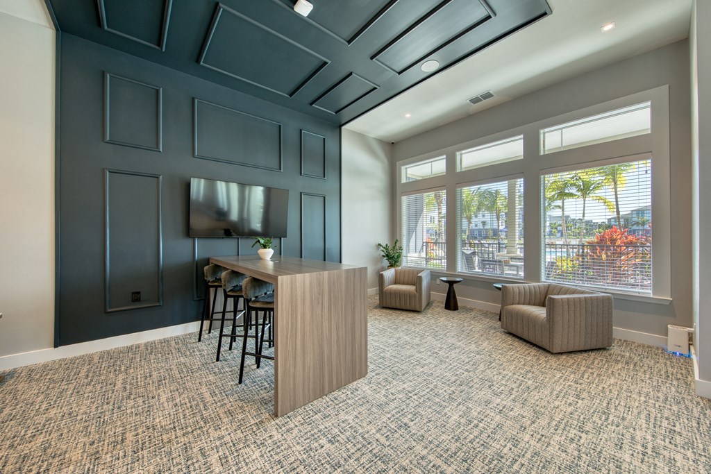 a conference room with a desk and chairs and a large window