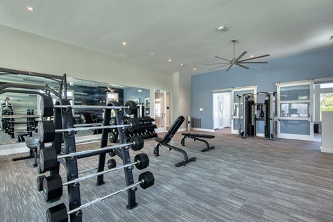 a gym with weights and cardio equipment in a building with blue walls
