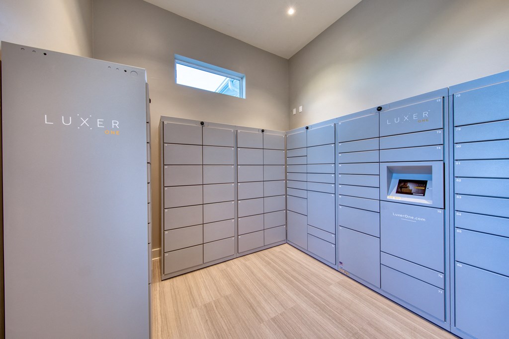 a large locker room with blue lockers and a wooden floor