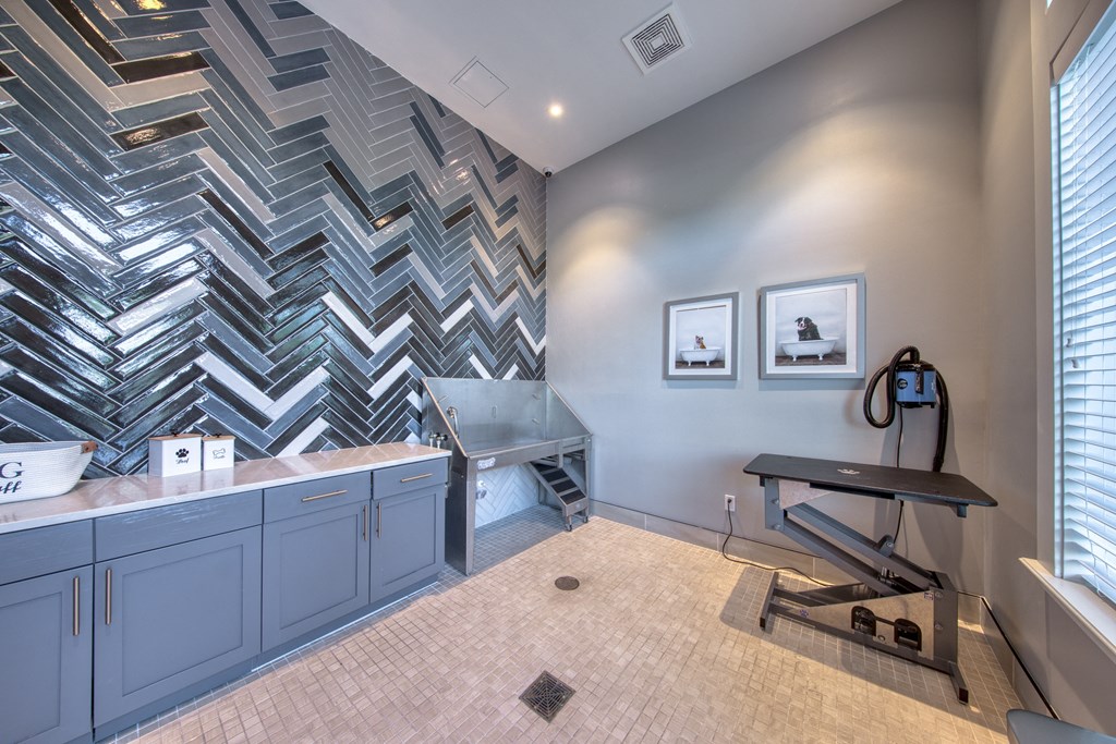a bathroom with a shower and sink and a checkered tile wall