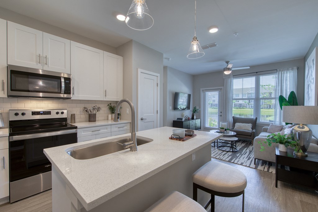 an open kitchen and living room with a large white counter top