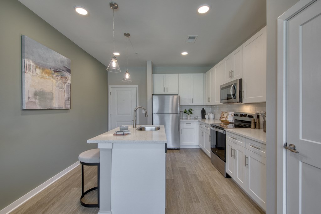 an open kitchen with white cabinets and stainless steel appliances