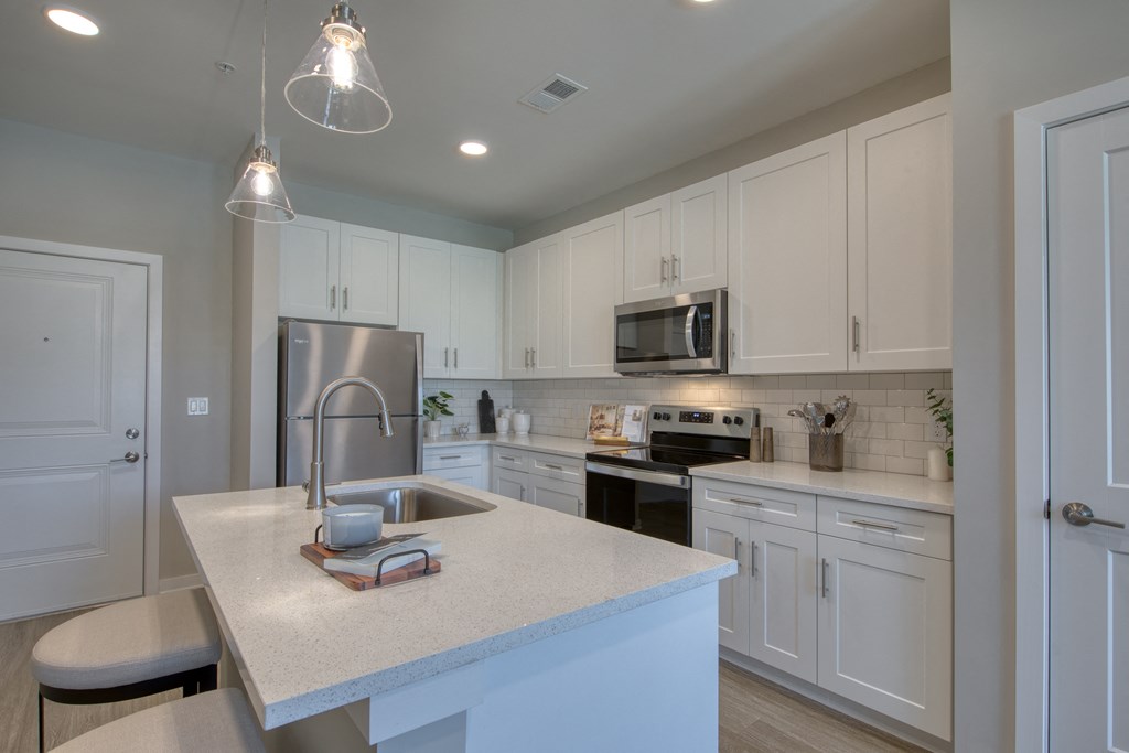 a kitchen with white cabinets and a white counter top