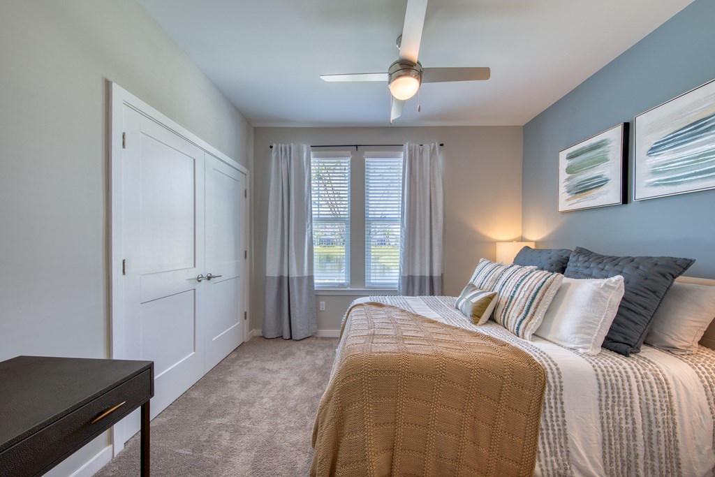 a bedroom with a large bed and a ceiling fan