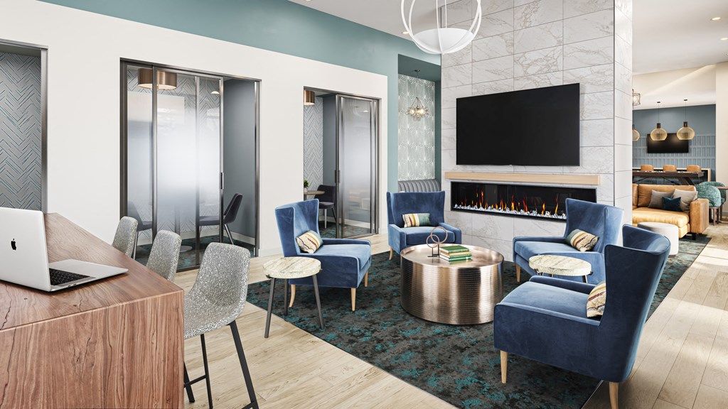 a living room with blue chairs and a table with a laptop