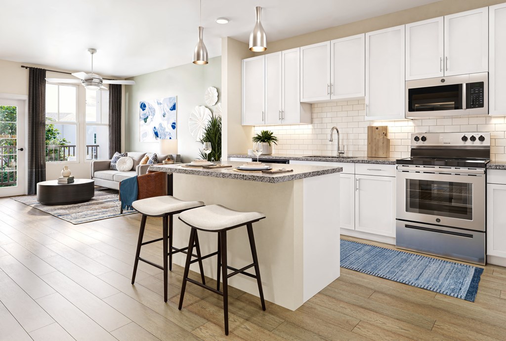 a kitchen and living room with white cabinets and a counter top
