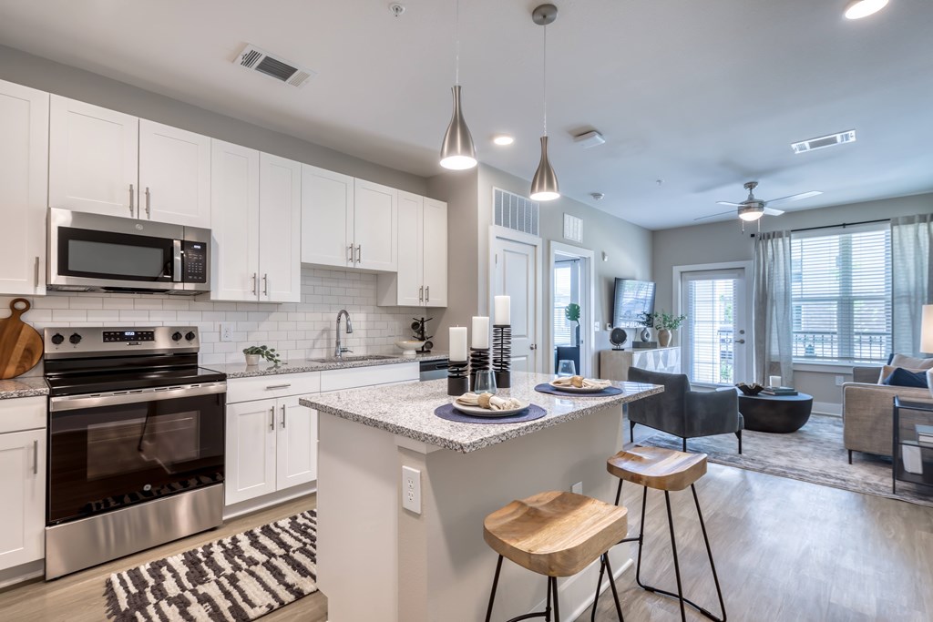 A modern kitchen with a center island and stools.