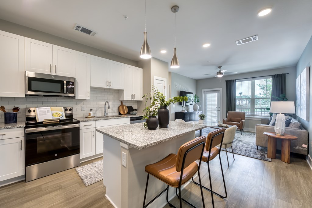 A modern kitchen with white cabinets and a large island.