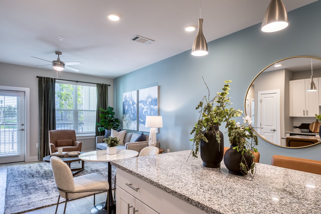 A kitchen with a table and chairs and a fan.