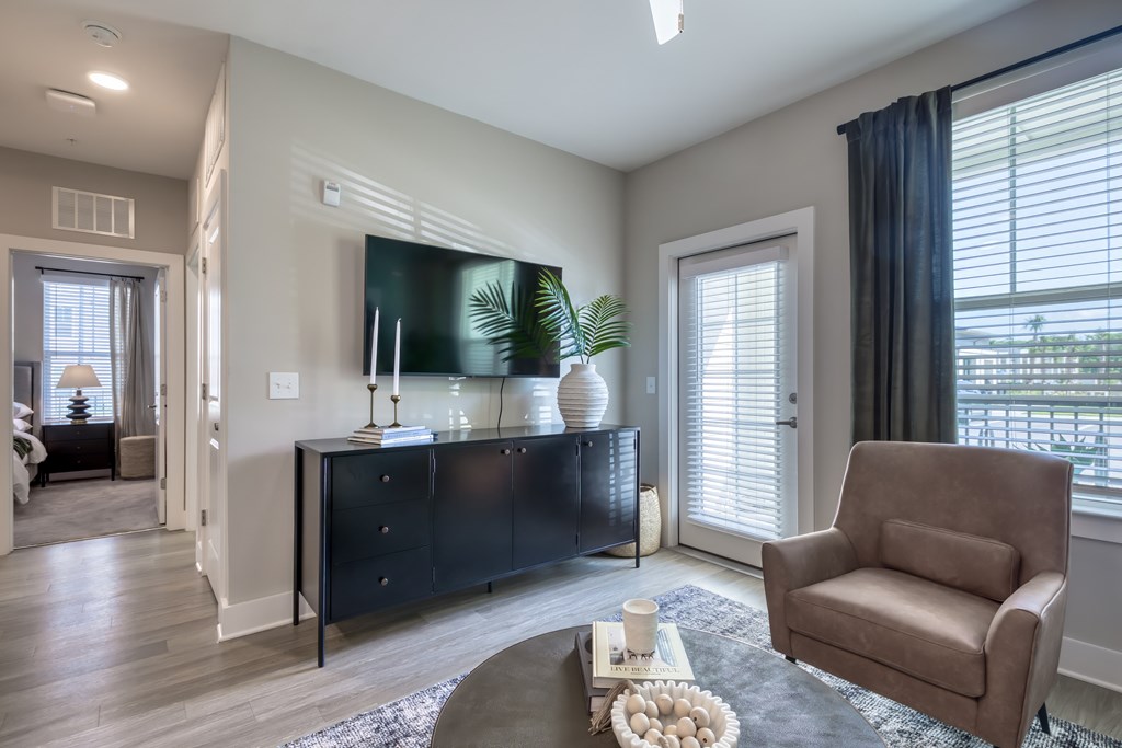 A living room with a brown chair and a black cabinet.