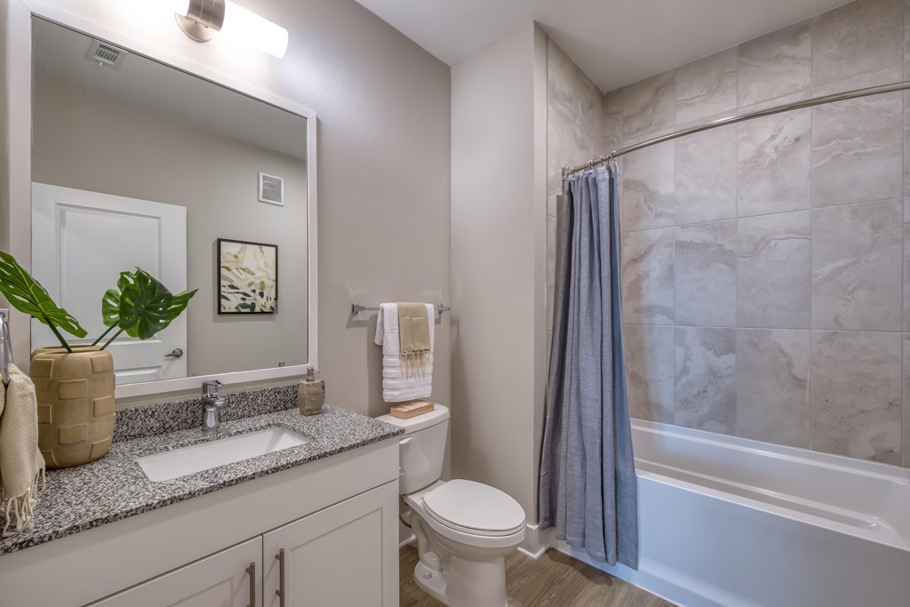 A bathroom with a toilet, sink, and bathtub.