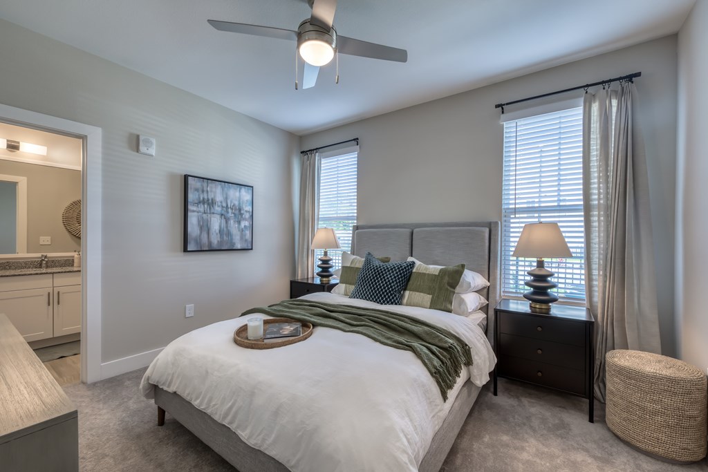 A bedroom with a bed, nightstand, and a ceiling fan.
