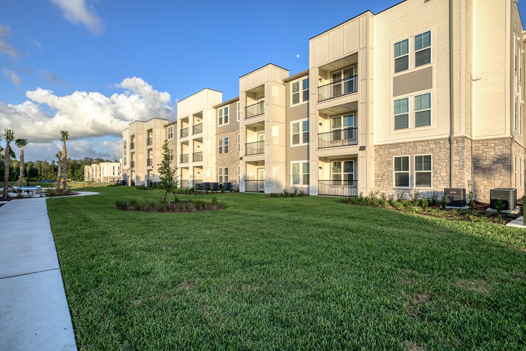 Apartment complex with a green lawn in front.