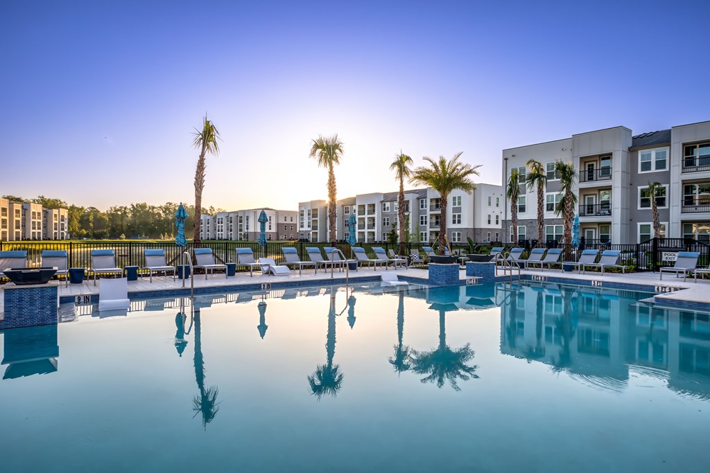 A pool with palm trees reflected in the water.
