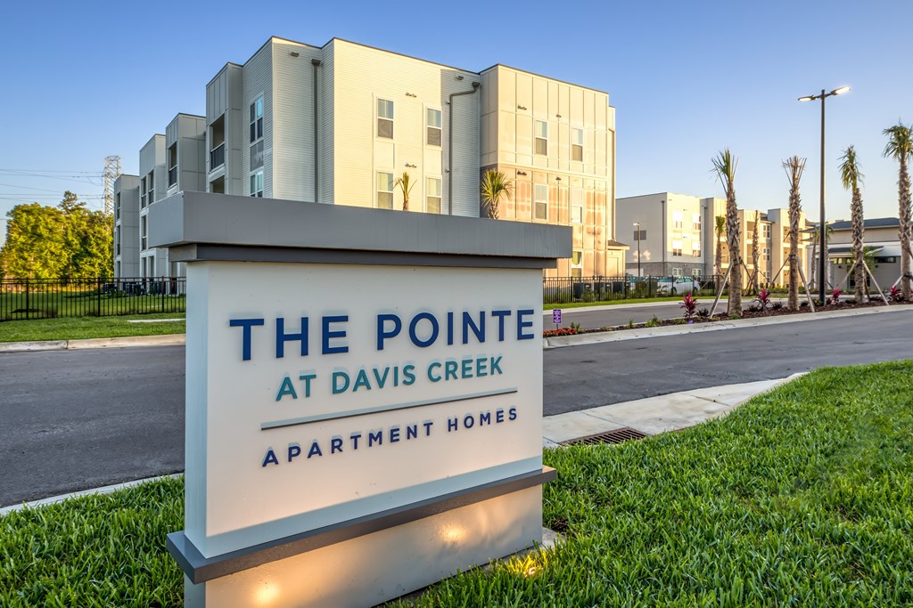 A sign for The Pointe at Davis Creek Apartment Homes is in front of a building.