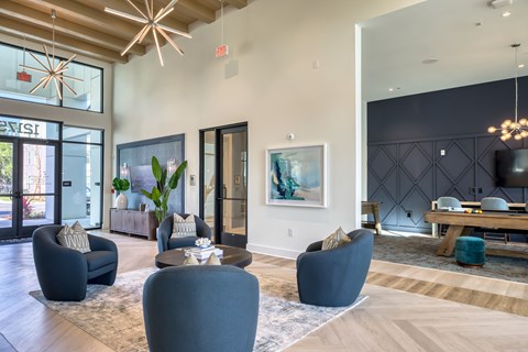 A modern living room with a large painting on the wall and a dining table with chairs.