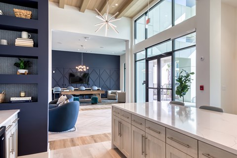 A modern kitchen with a blue chair and a dining table.