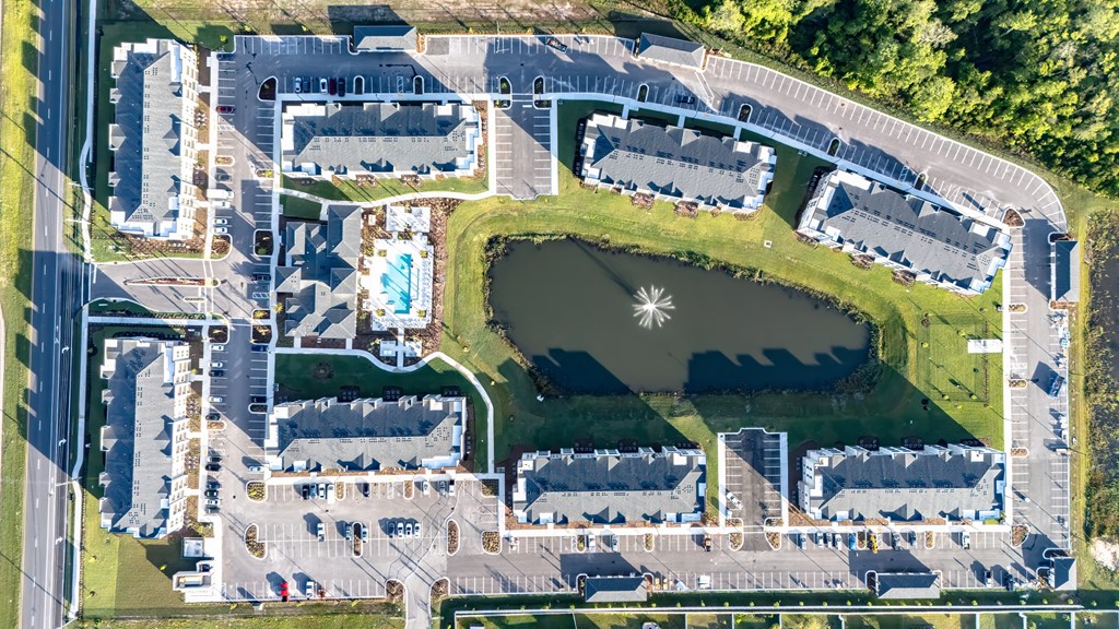 An aerial view of a large complex with a lake in the middle.