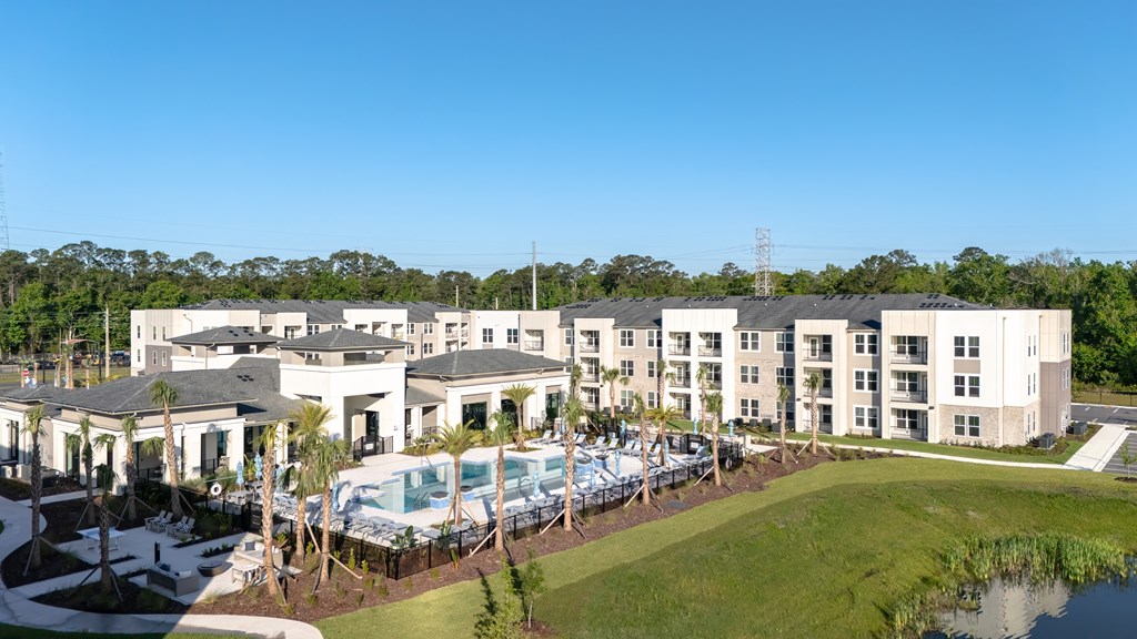 A large white building with a pool in front.