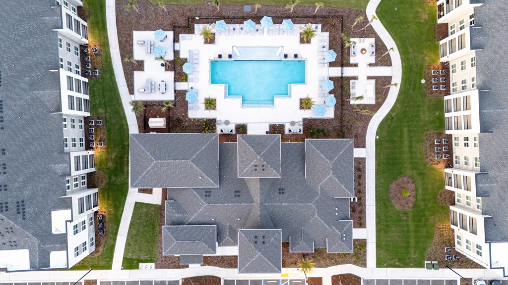 A bird's eye view of a residential area with a swimming pool.