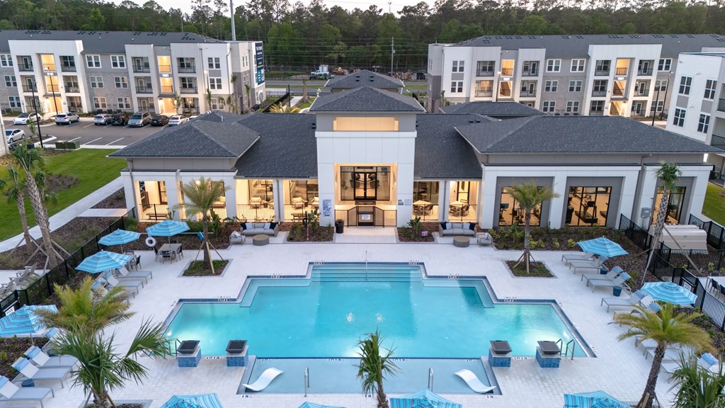A large white building with a pool in front.