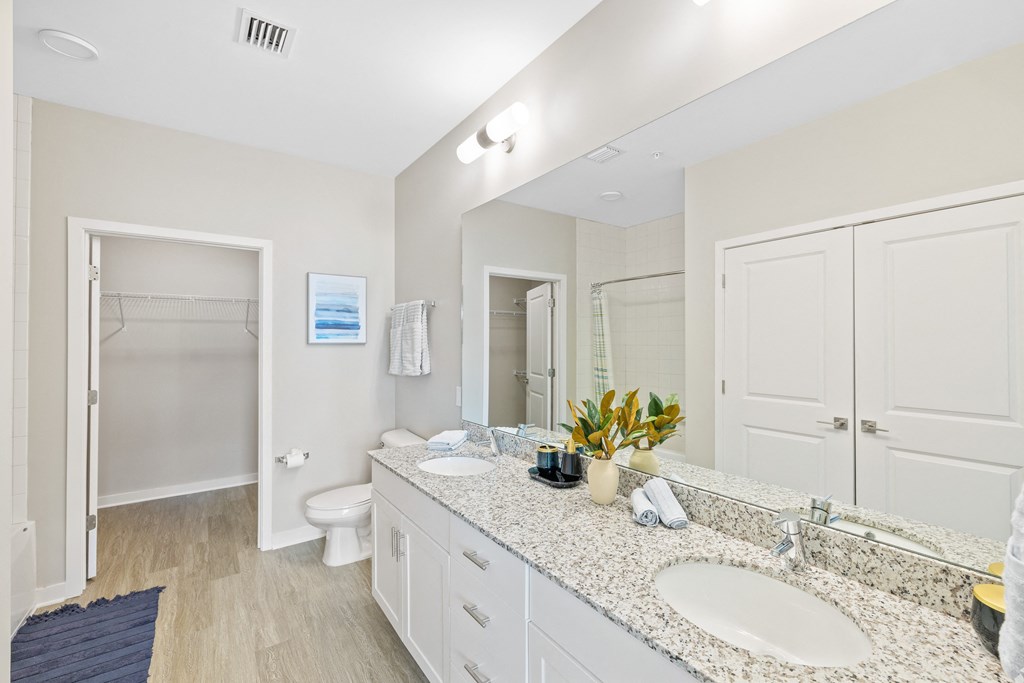 a bathroom with two sinks and a shower and a toilet