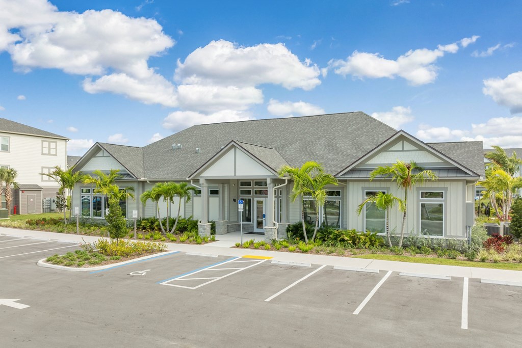 an empty parking lot in front of a building with palm trees