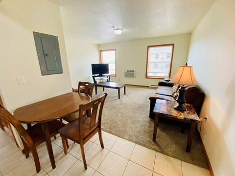A living room with a brown table and chairs.