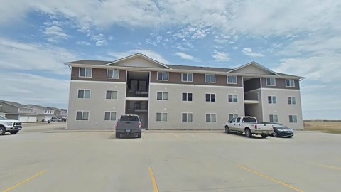 A large building with a parking lot in front of it.