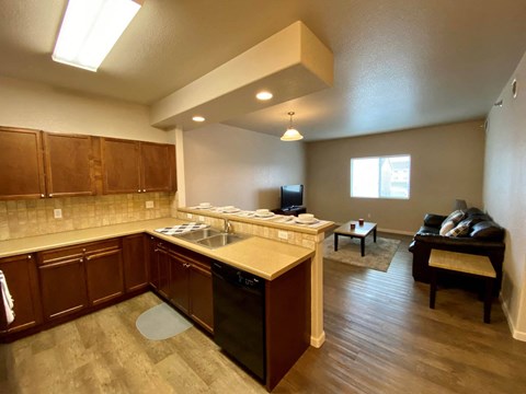 A kitchen with wooden cabinets and a black dishwasher.