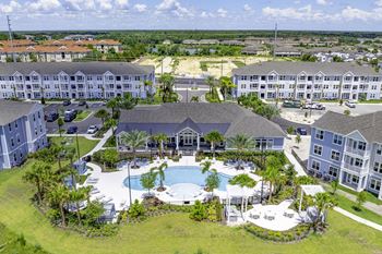 A large resort with a pool and palm trees.