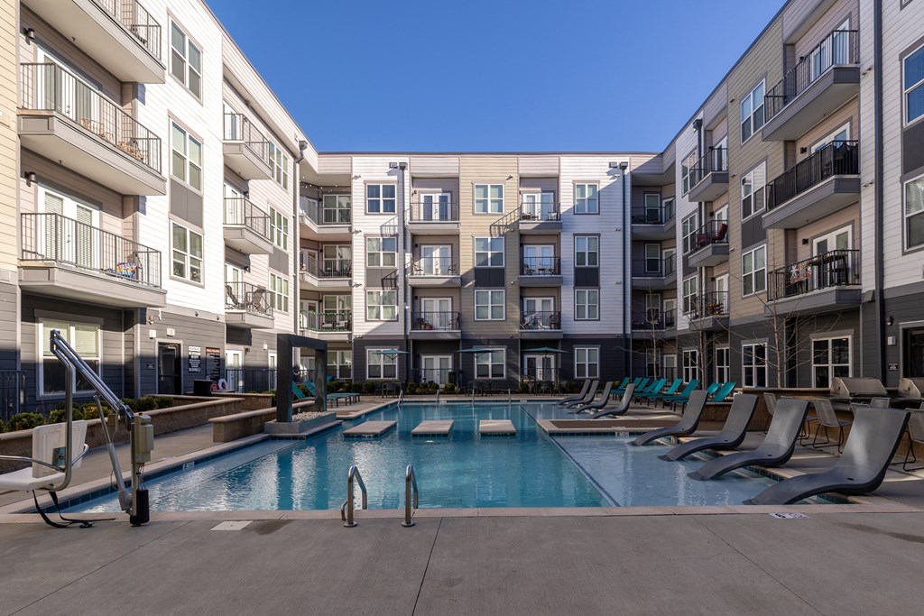 an apartment swimming pool in front of an apartment building