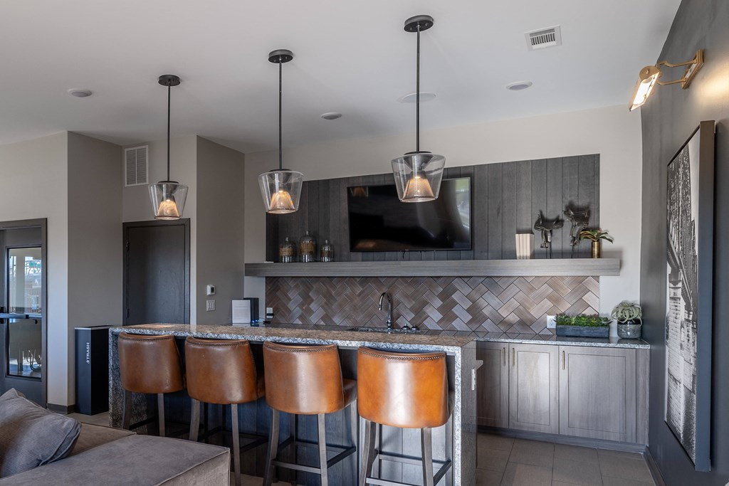 a bar with four stools in a living room with a television
