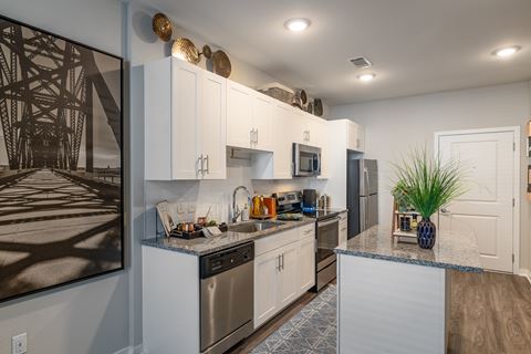a kitchen with white cabinets and stainless steel appliances and a counter top
