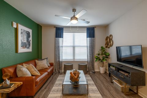 a living room with green walls and a brown leather couch