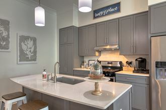 a kitchen with gray cabinets and a white counter top