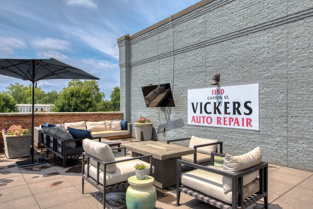 a patio with couches and chairs and a tv