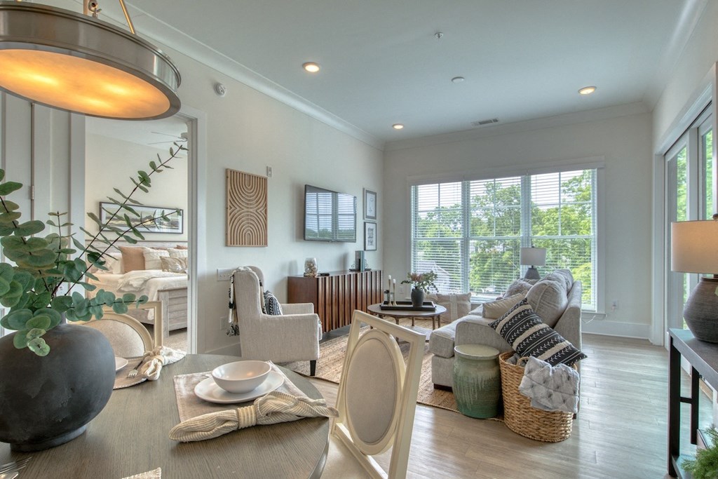 a living room and dining room with a table and chairs
