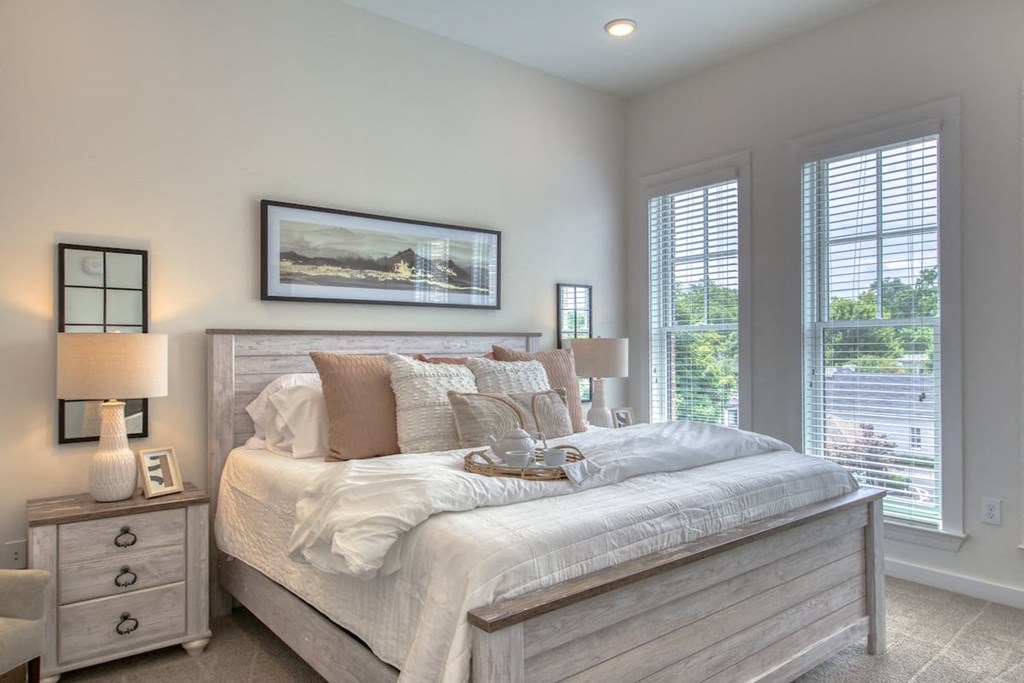 a bedroom with a bed and two windows