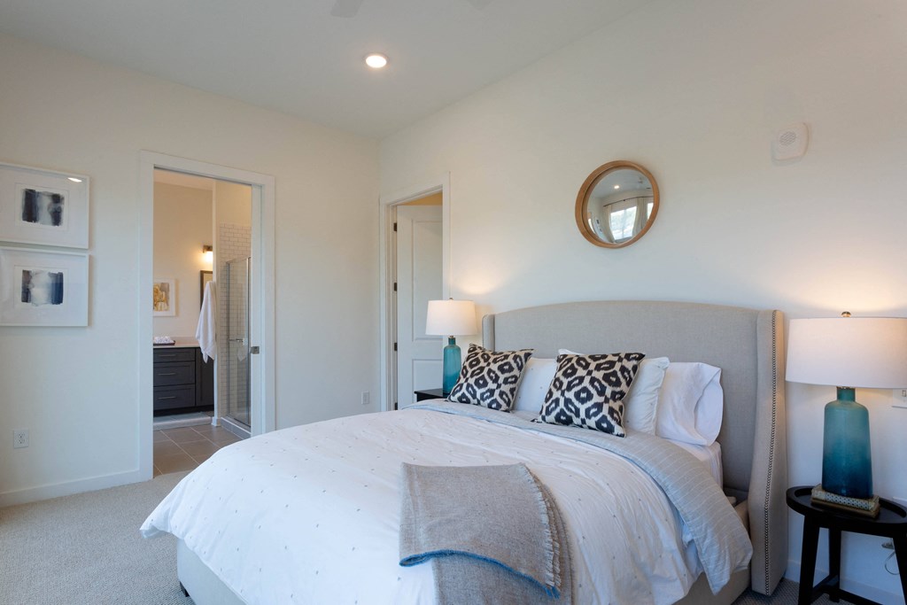 a bedroom with a large bed and a mirror on the wall