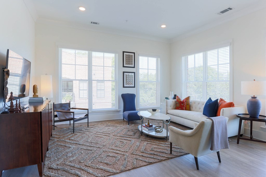 a living room with a couch and chairs and a tv
