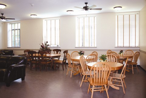 a dining room with tables and chairs and windows