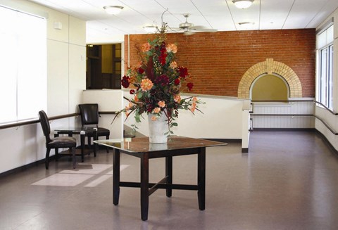 an empty room with a table with flowers on it